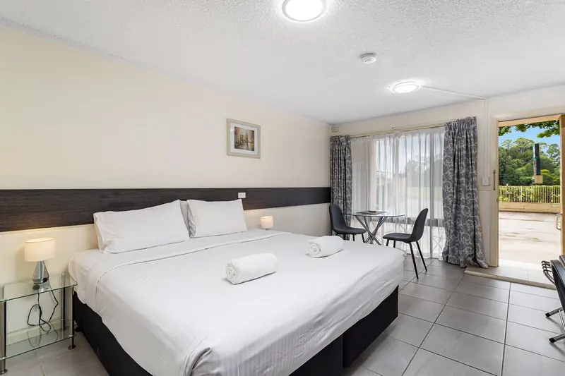 A king room at Gallery Motel with a dining table and doors onto the forecourt