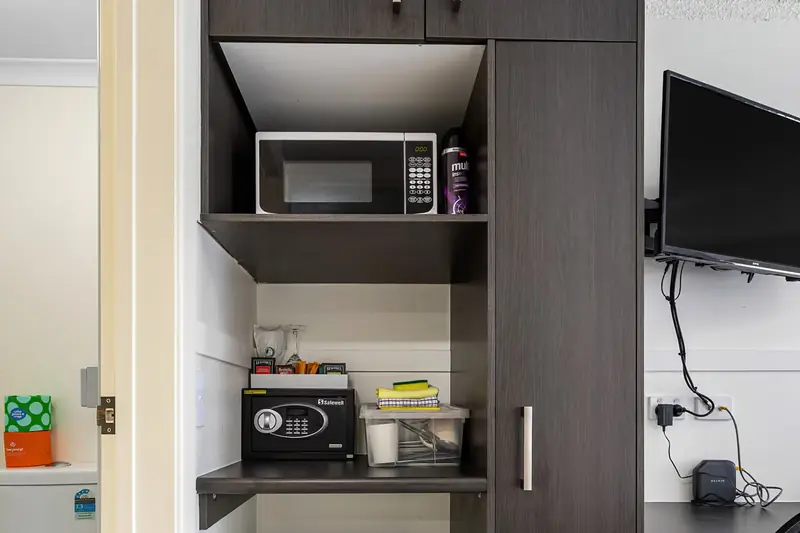 Kitchenette with a microwave, bar fridge and cupboard space